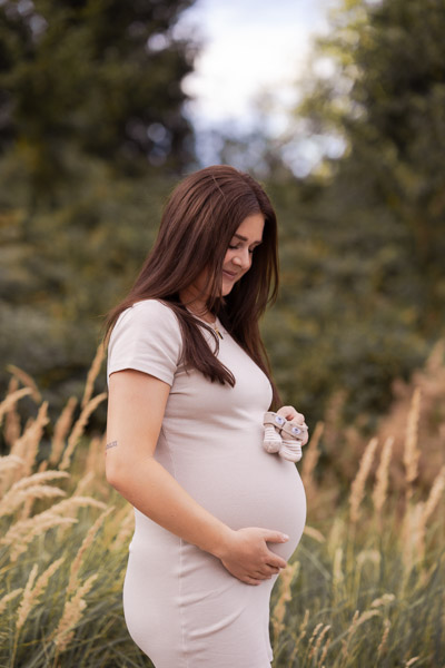 Startseite Eine schwangere Frau legt ihre Hand liebevoll auf ihren Bauch
